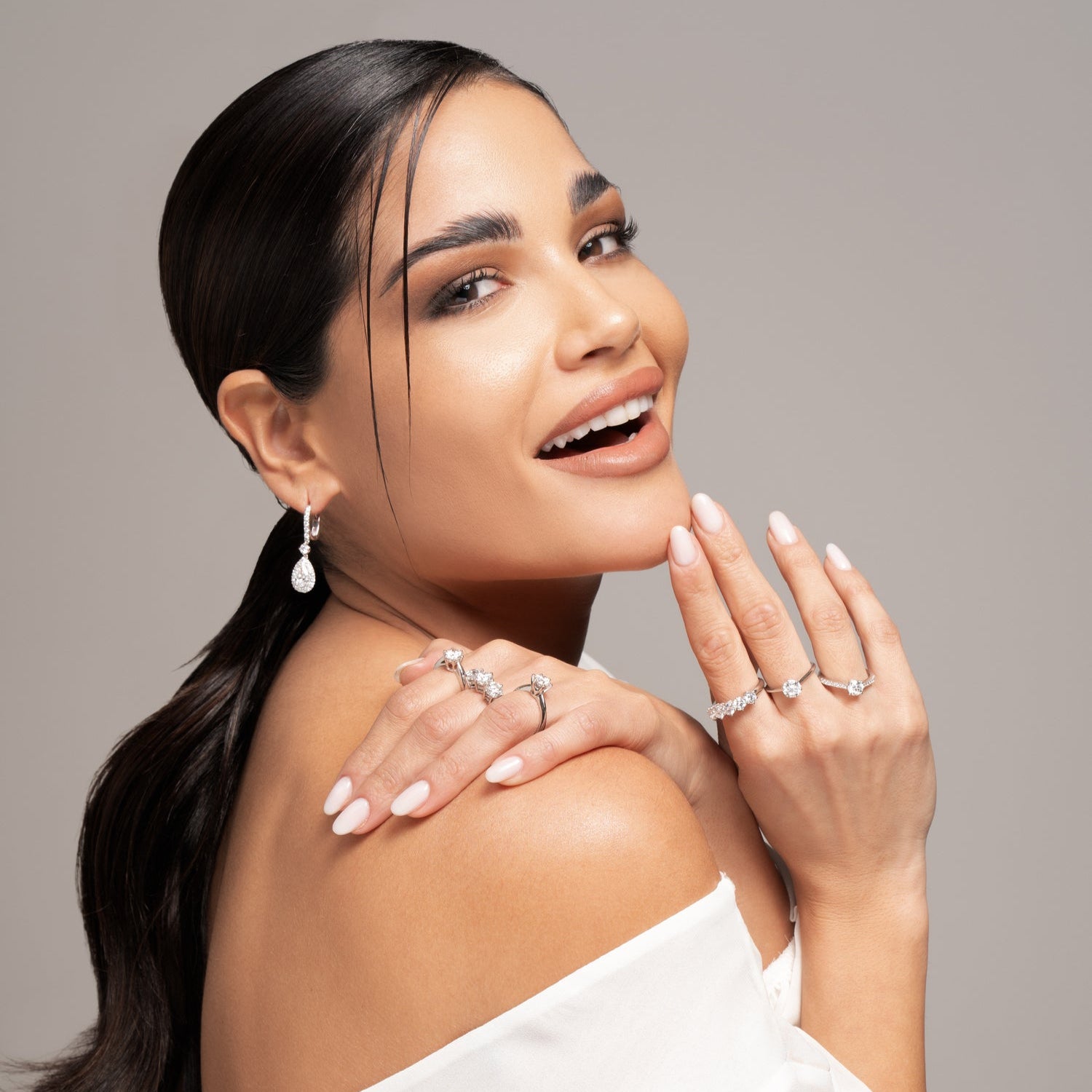 modella indossa anelli trilogy e solitario con diamanti lab grown e orecchini halo